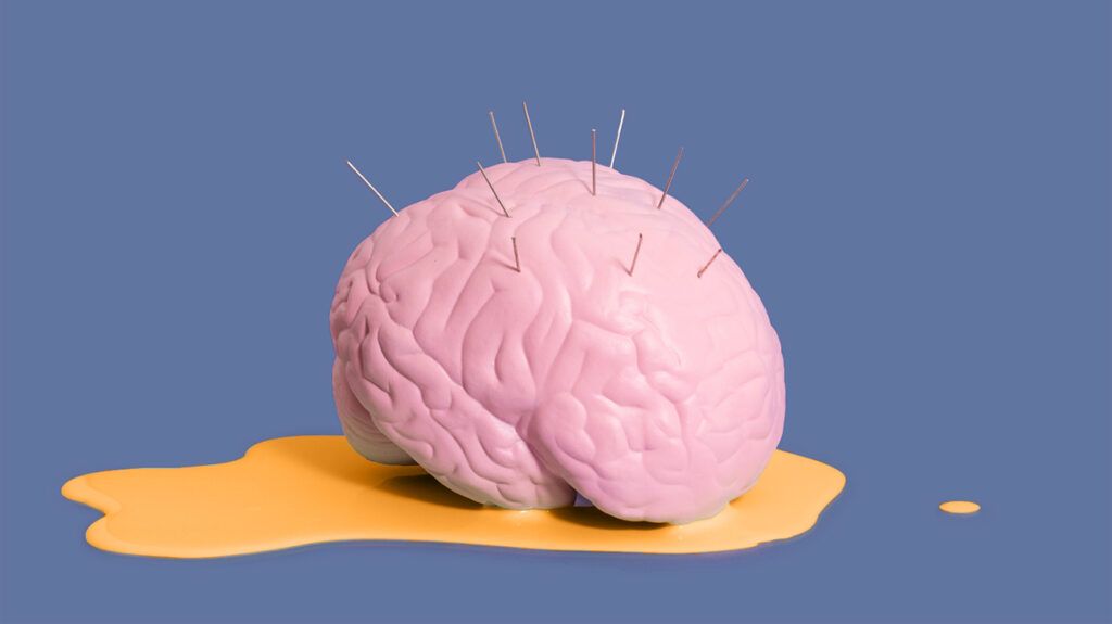 brain with pins sticking out and in an orange puddle