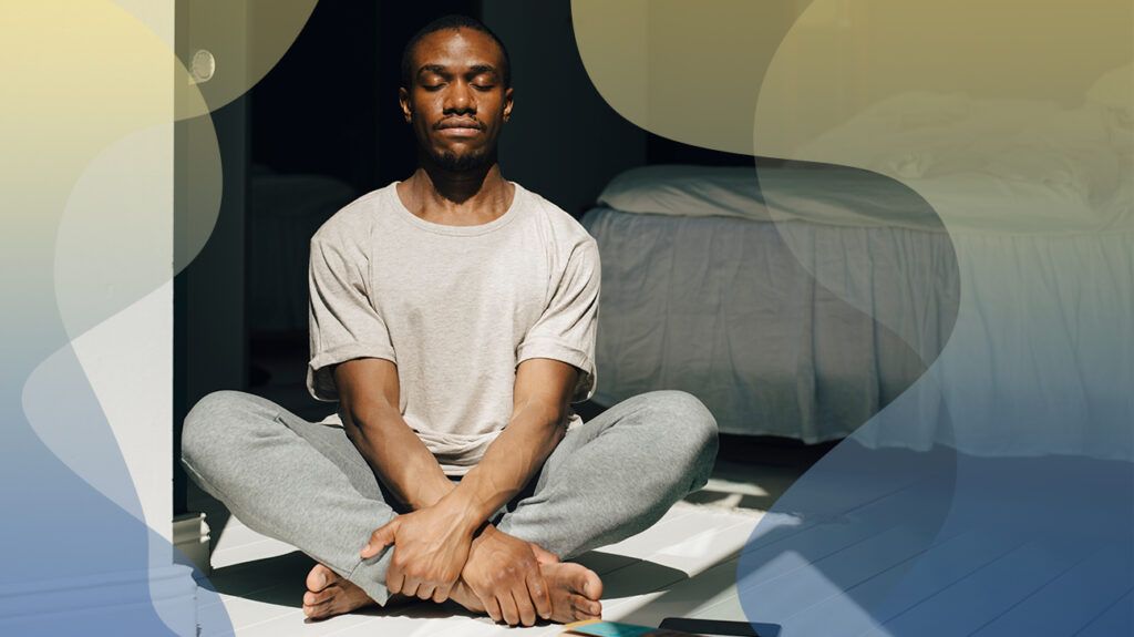 man sitting cross-legged on the floor meditating and relaxing