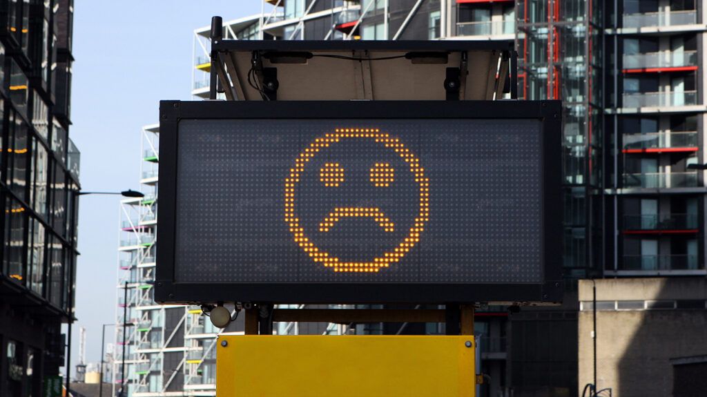 digital street sign displaying a sad face
