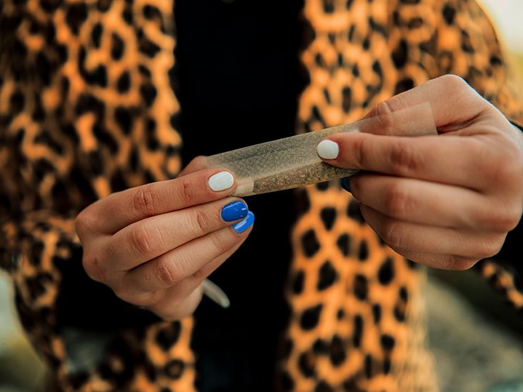 Person rolling medical cannabis into rolling paper to smoke