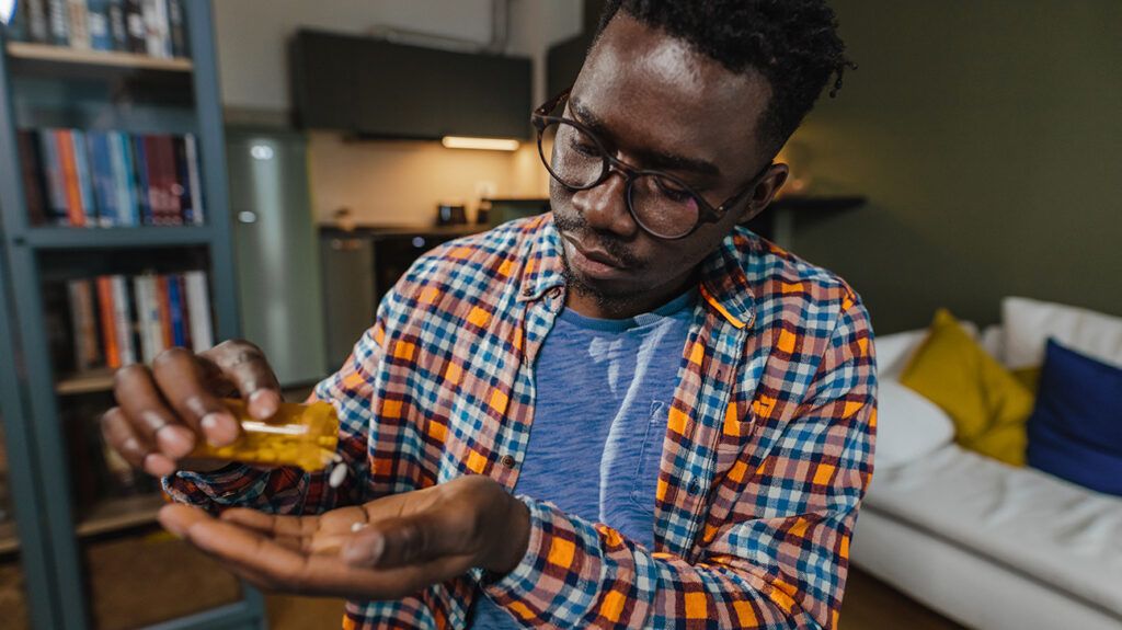 a man prescription pouring pills into his hand