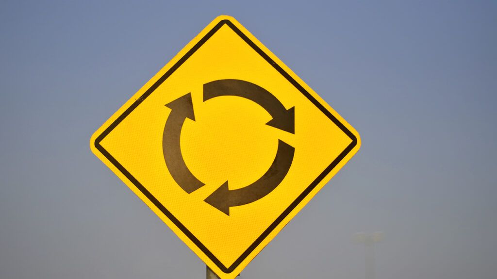 Yellow roundabout arrows road sign, symbolic of schizophrenia relapse 