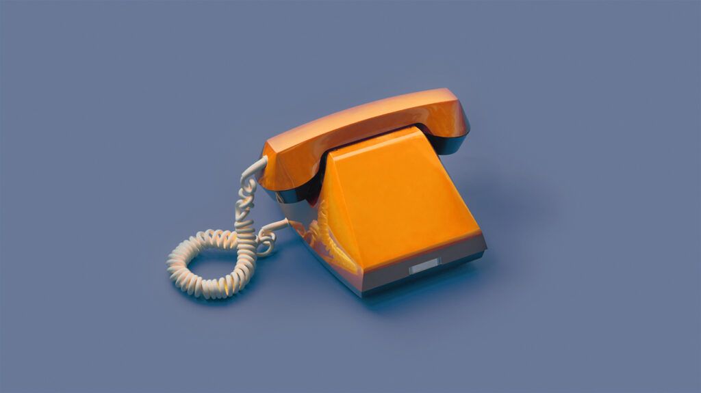 An orange telephone against a blue background