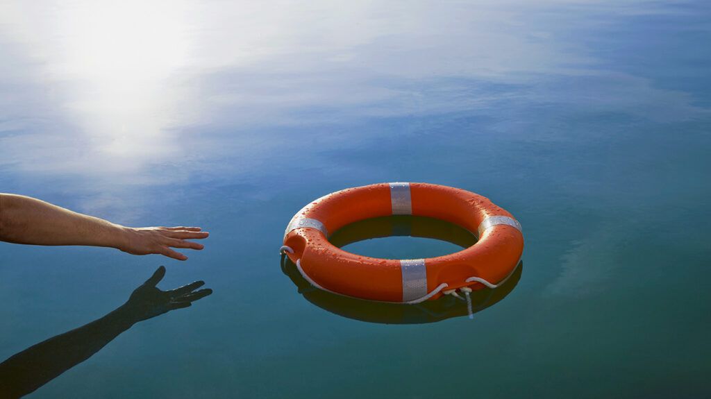 Hand reaching for lifesaver in water, symbolic of reaching for help with schizoaffective disorder