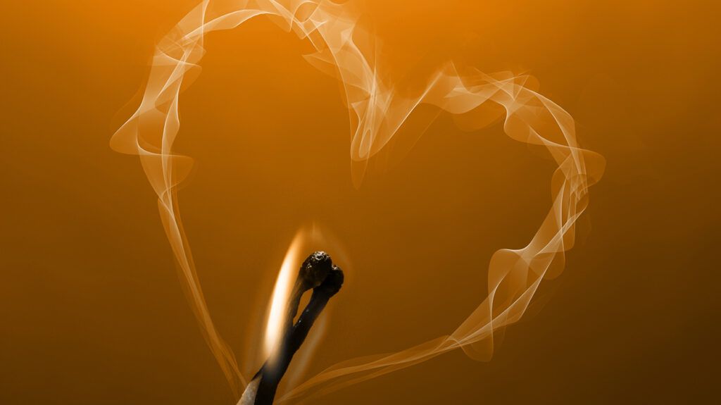 Two matches burning out, the smoke surrounding in the shape of a heart