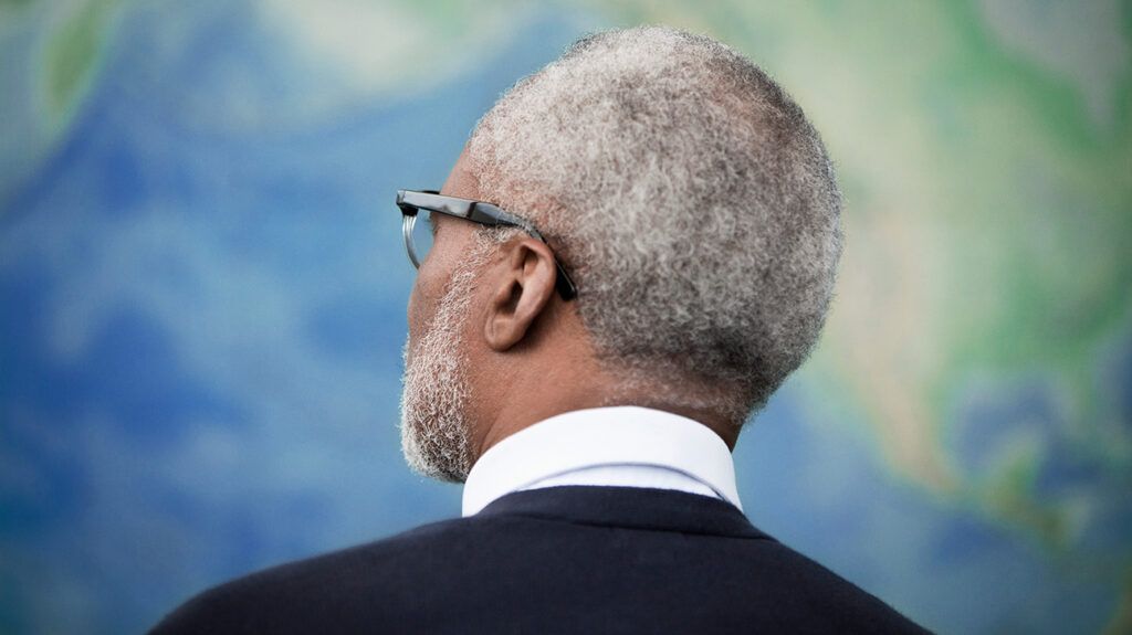 close up of a man with grey hair looking at a map