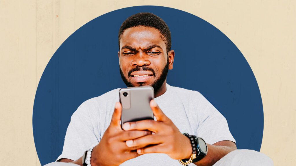 Man looking at his cell confused, as he received a backhanded compliment