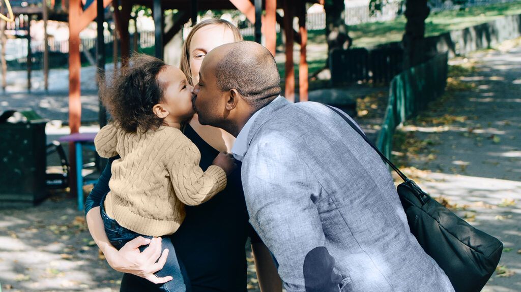 father kissing his child goodbye as he transfers to ex wife for co-parenting timeshare