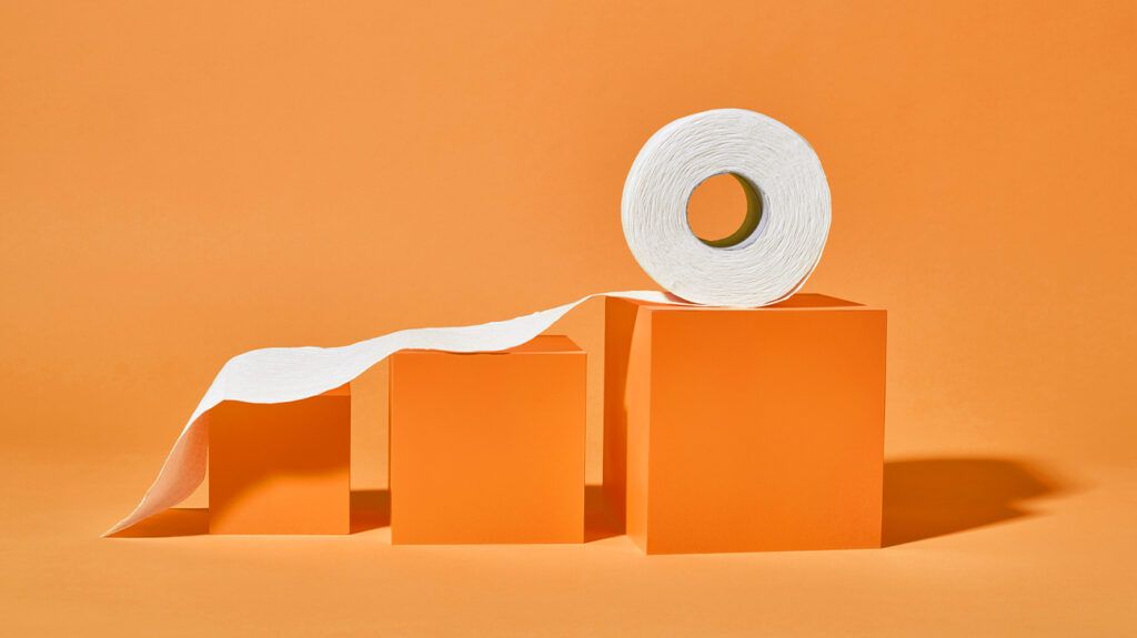 Toilet paper unraveling up increasingly bigger blocks, symbolic of anxiety and poop urge