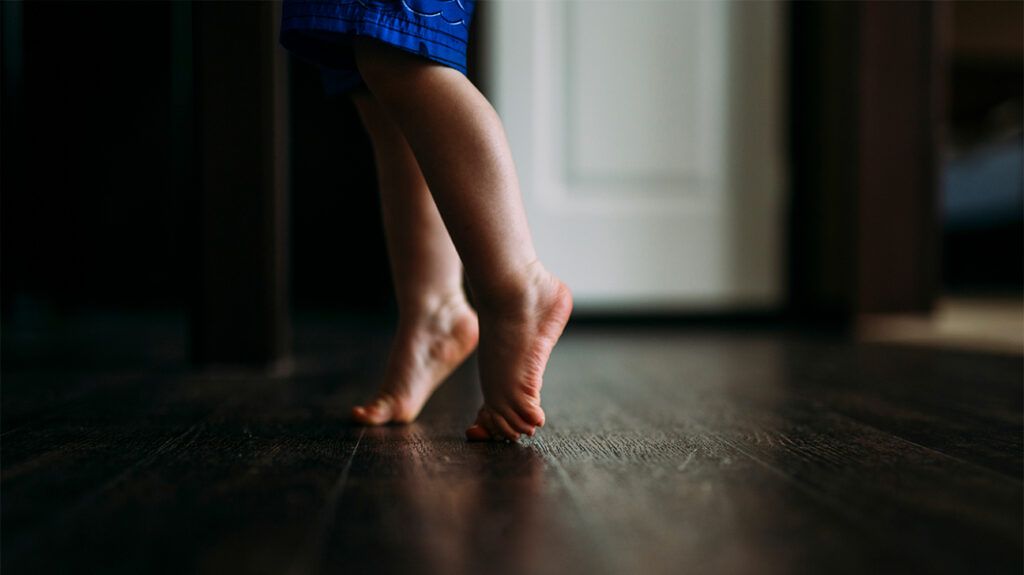 a toddler walking on their tiptoes