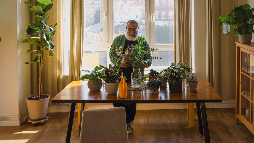 a man caring for his houseplants 