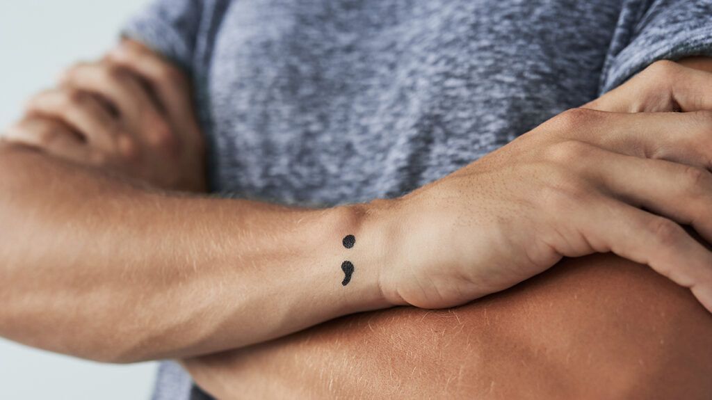 semicolon tattoo on a mans wrist