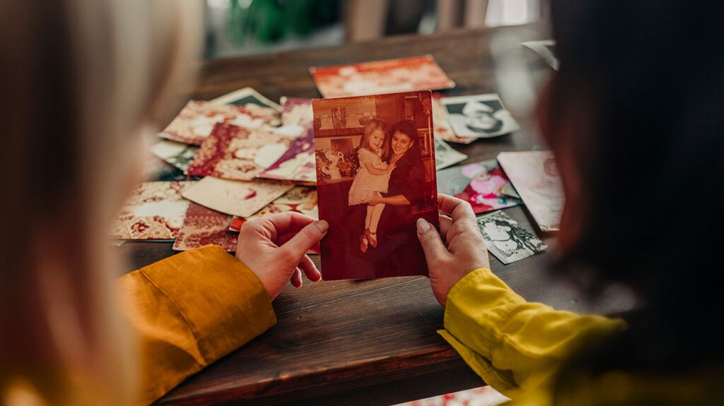 a mother and daughter using explicit memory looking at family photos