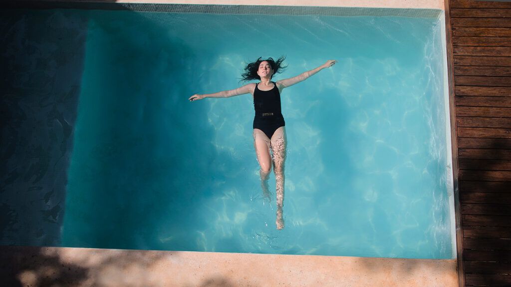 a woman spending time floating in a pool alone