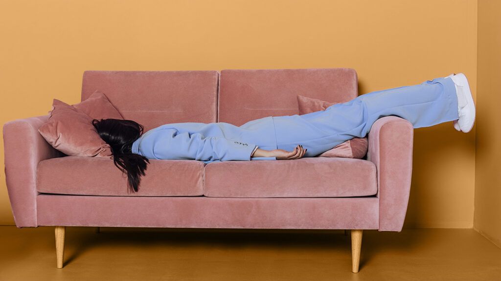a woman lying face down on a sofa