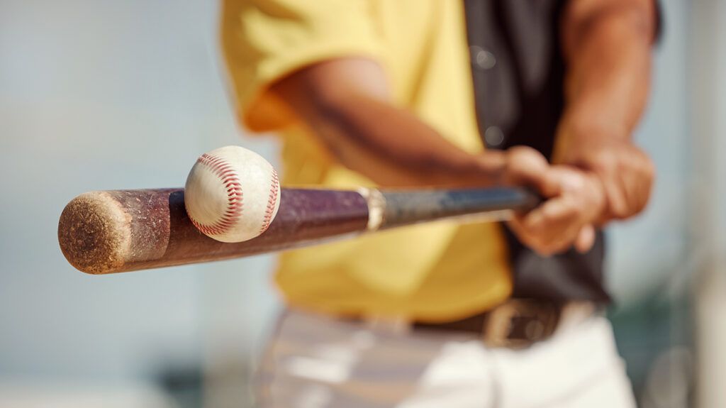 close up of a baseball player hitting the ball with their bat