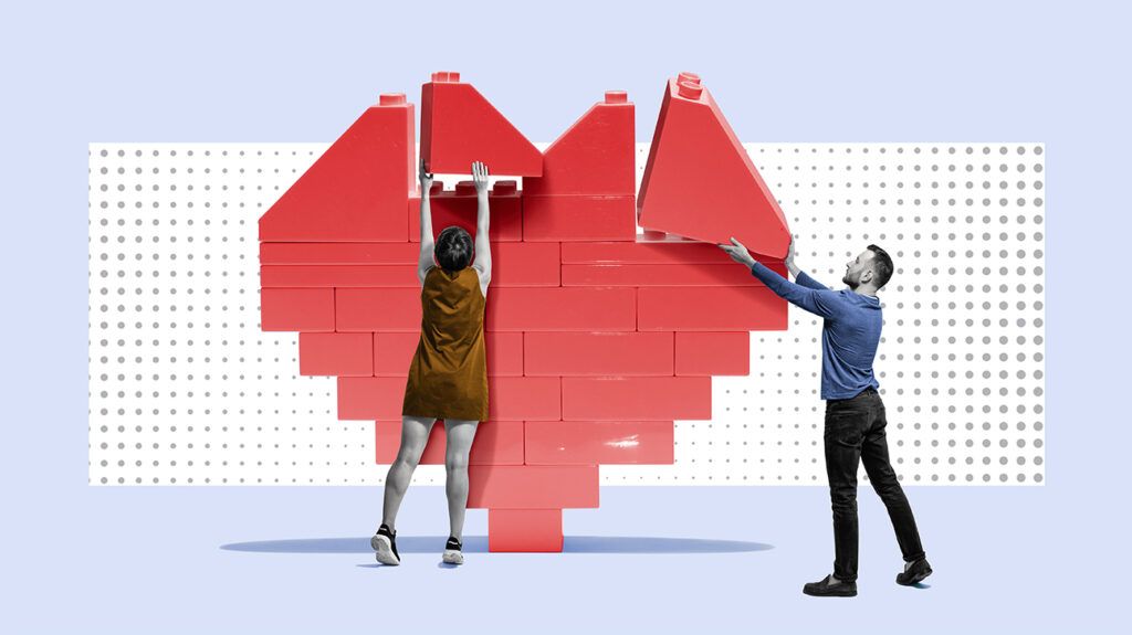 a couple building a large heart out of blocks