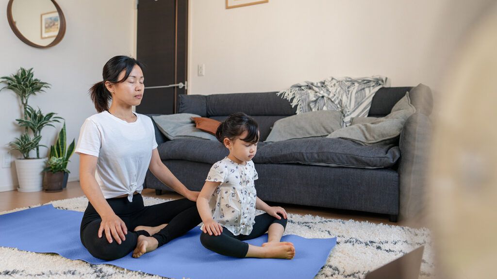 a mother and her child meditating at home