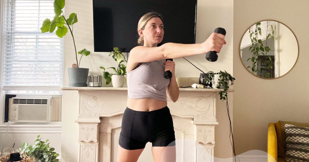 The author uses dumbbells to exercise in her living room.