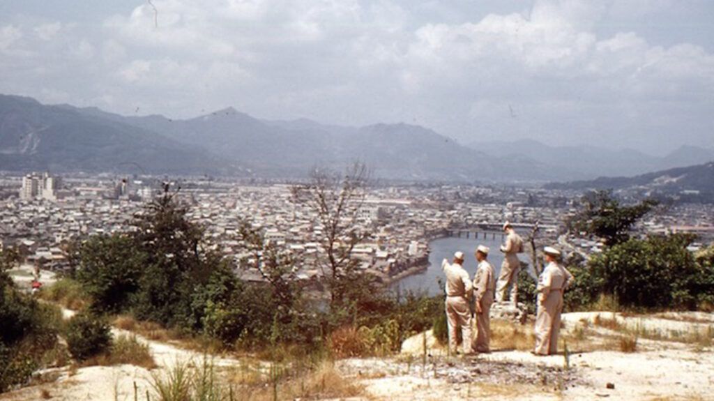 United States soldiers on a hill overlooking Nagasaki in the late 1940s.