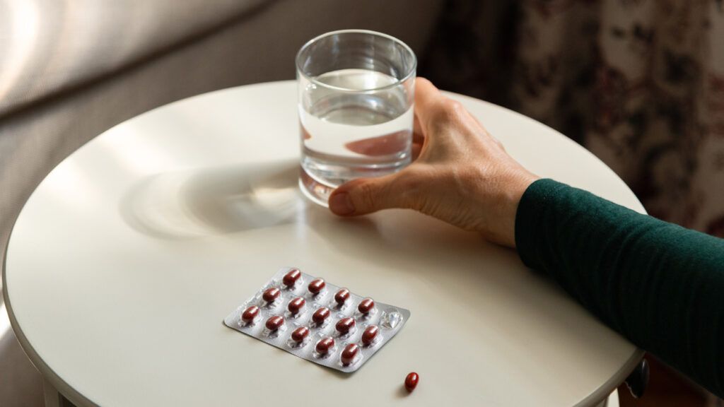 Medication and a glass of water on a table