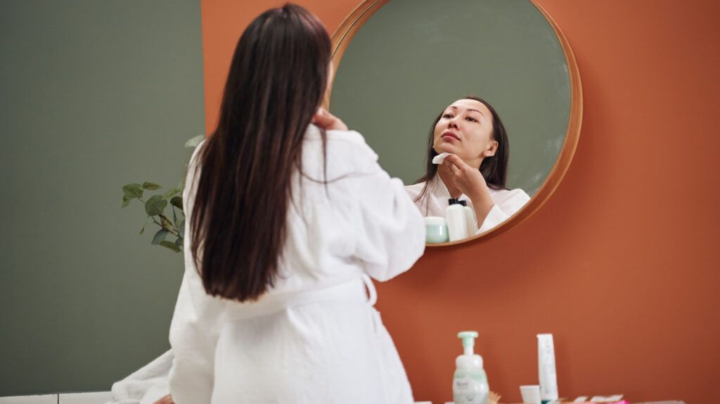 A person looking at their skin in a mirror