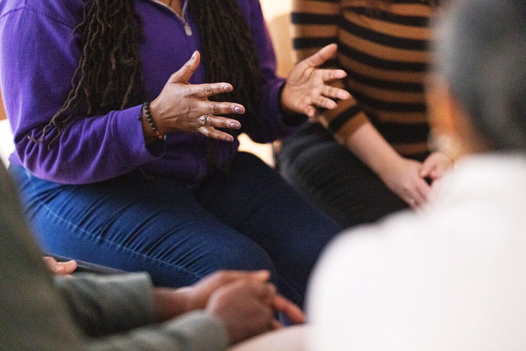 A person gesturing with their hands during a group therapy session