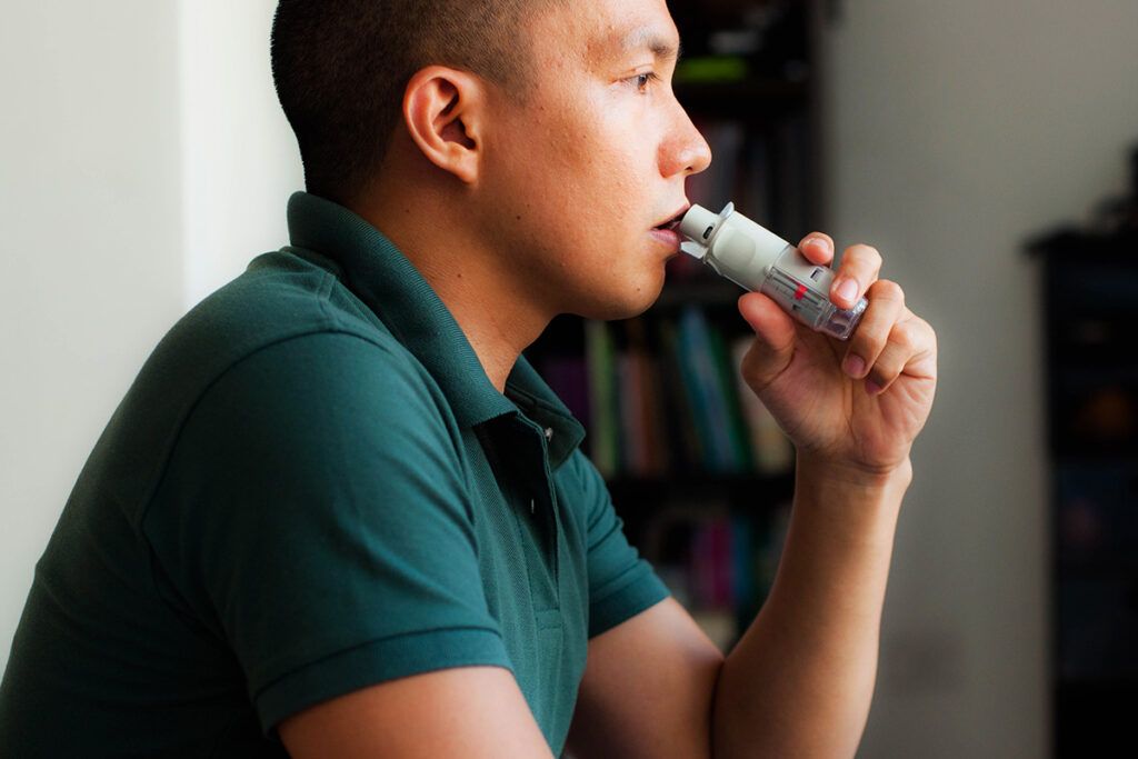 A person using an inhaler