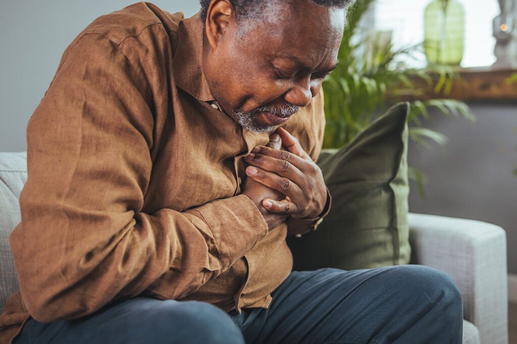 Older man grabbing his chest in signs of pain