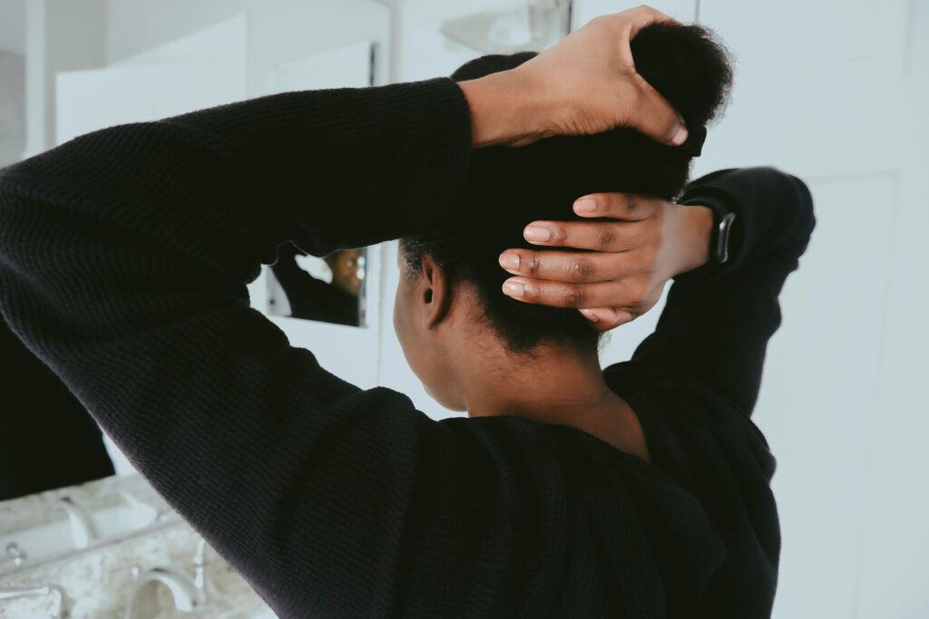 A person holding their hair and touching their head