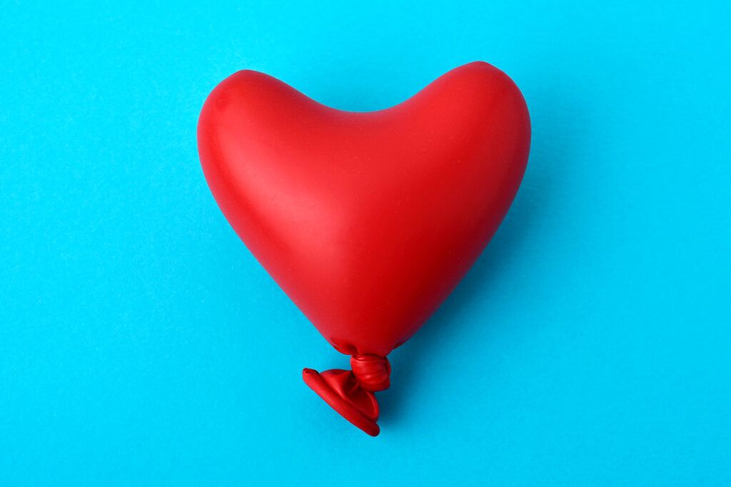 A red heart shaped balloon on a blue background. Representing the question can high blood pressure cause anxiety