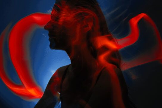 Silhouette of young woman with light painting trails