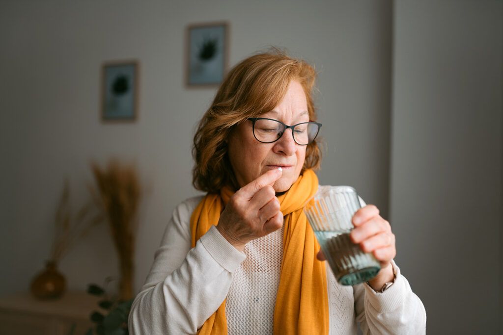 A person taking migraine prevention pills.