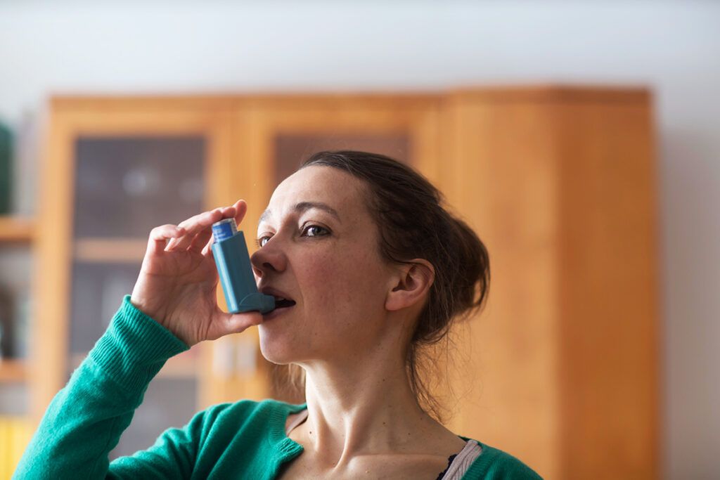 An image of someone using an inhaler.