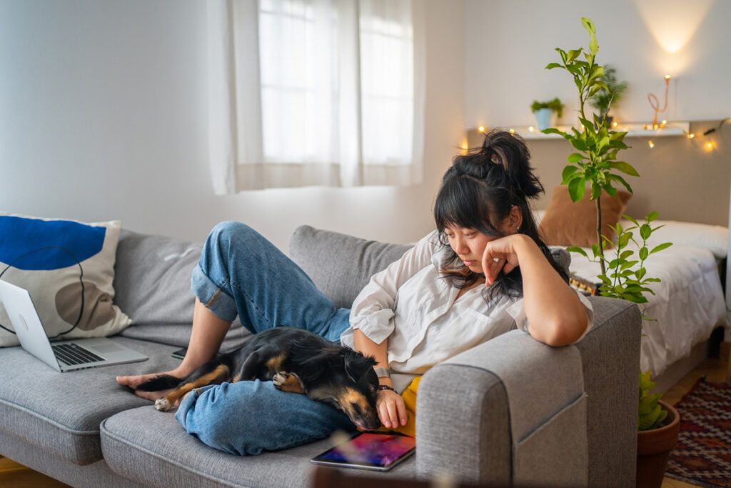 Young female sitting on the couch with a dog