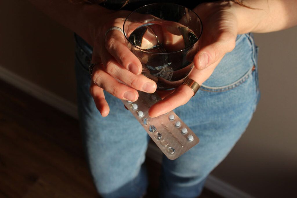 person with pills to delay period
