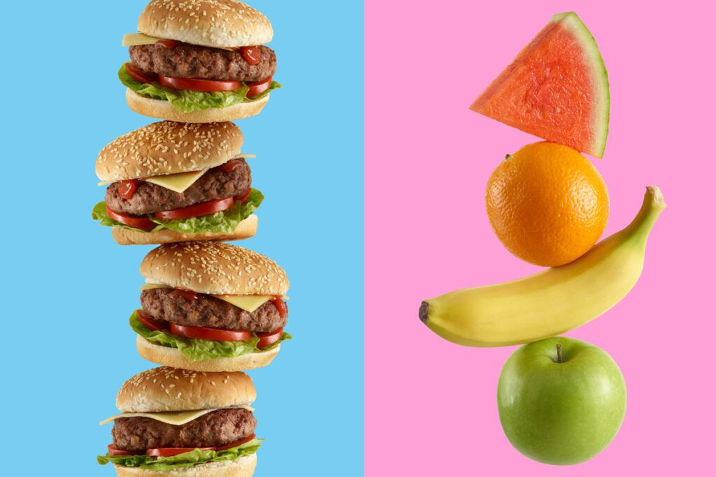 A vertical stack of hamburgers on the left and a vertical stack of fruit on the right. From top top to bottom the fruit is a slice of watermelon, and orange, a banana, and a apple. Depicting the worst foods for cholesterol