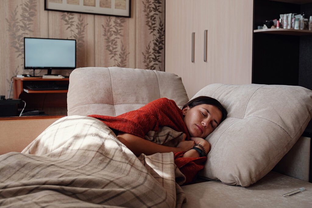 Woman with Crohn's disease flare up resting in a couch