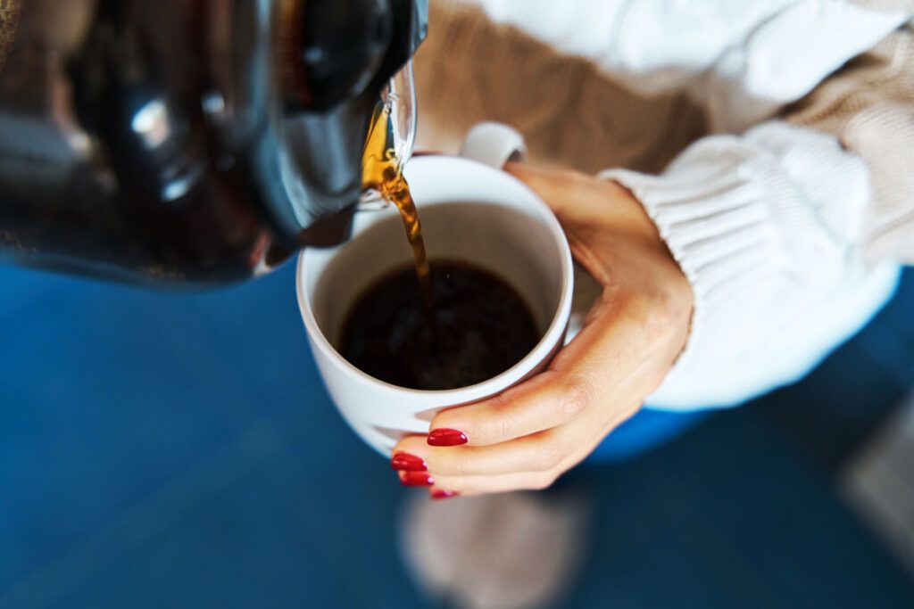 Close up of a person pouring coffee from a coffee pot but people also sometimes use coffee to perform a coffee enema