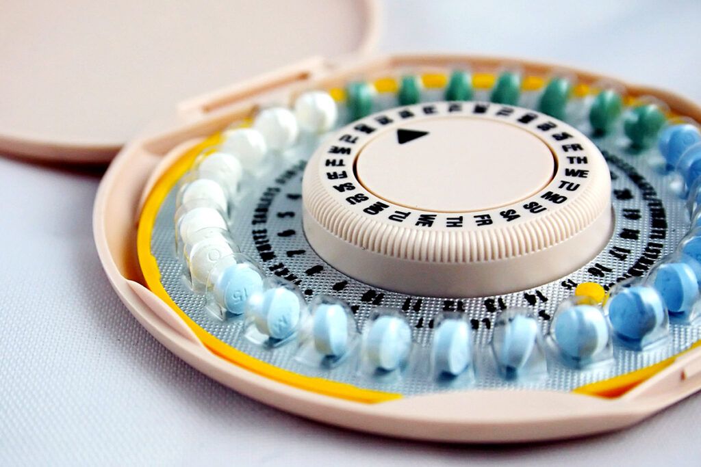 A round birth control case displaying a monthly dosage.