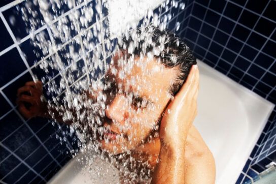 Man taking cold shower after waking up with anxiety