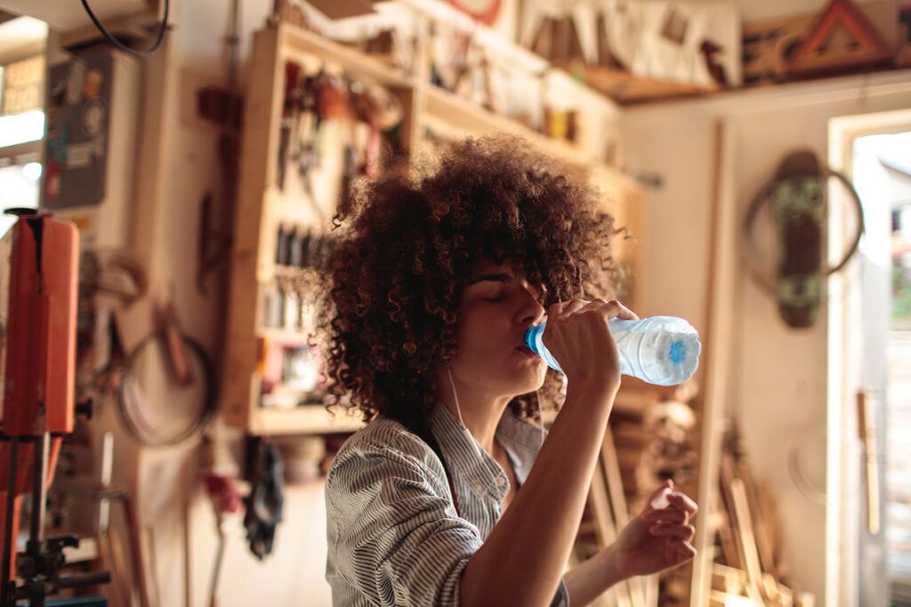 Person drinking from a waterbottle.