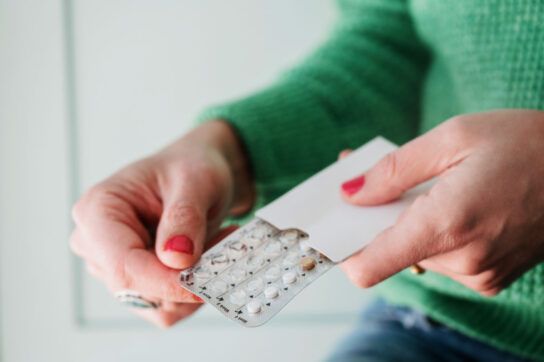 Person holding a packet of birth control pills.