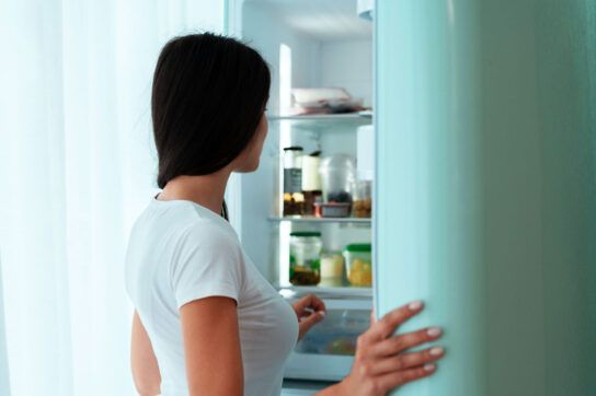 Adult female looking in fridge wondering about which foods create brown fat