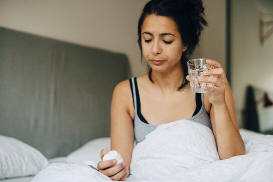 Woman taking ACE inhibitor lisinopril with a glass of water