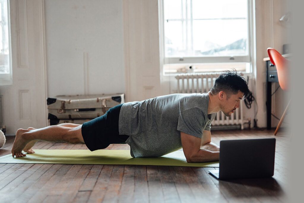 A man doing a plank on a yoga mat, which is a way to boost testosterone.