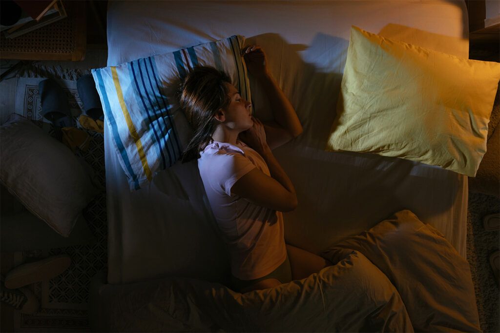 A female laying in bed to depict the insomnia medication Ambien.