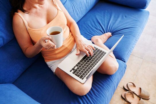 Woman on her laptop while taking metoprolol in the morning with tea