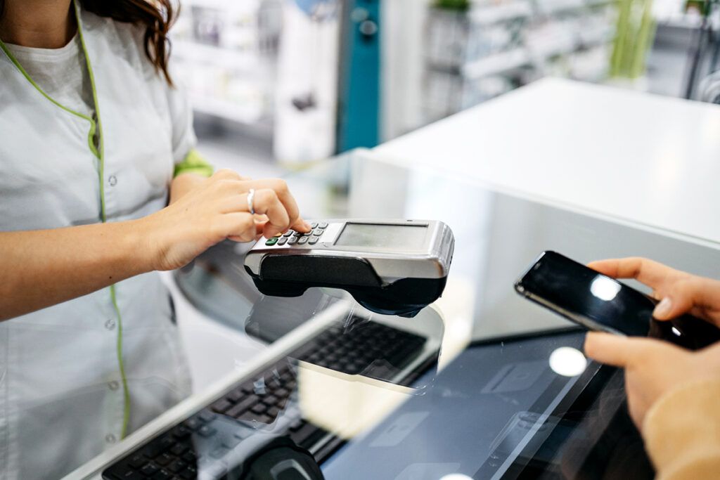 Customer using a legitimate prescription discount card on their phone at a local pharmacy