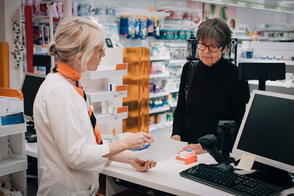 A person speaking with a pharmacist about generic vs. branded drugs.